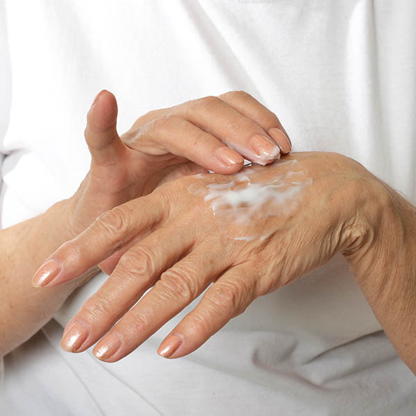 Woman applying cream to the back of her hand