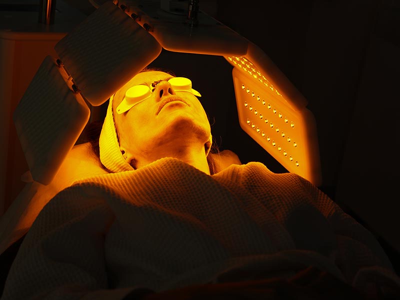 LED phototherapy / light therapy using yellow light on a woman's face