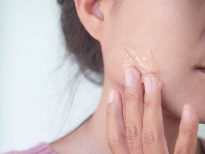 Woman applying gel to face