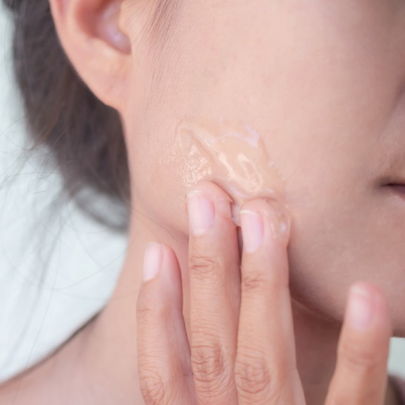 Woman applying gel to face